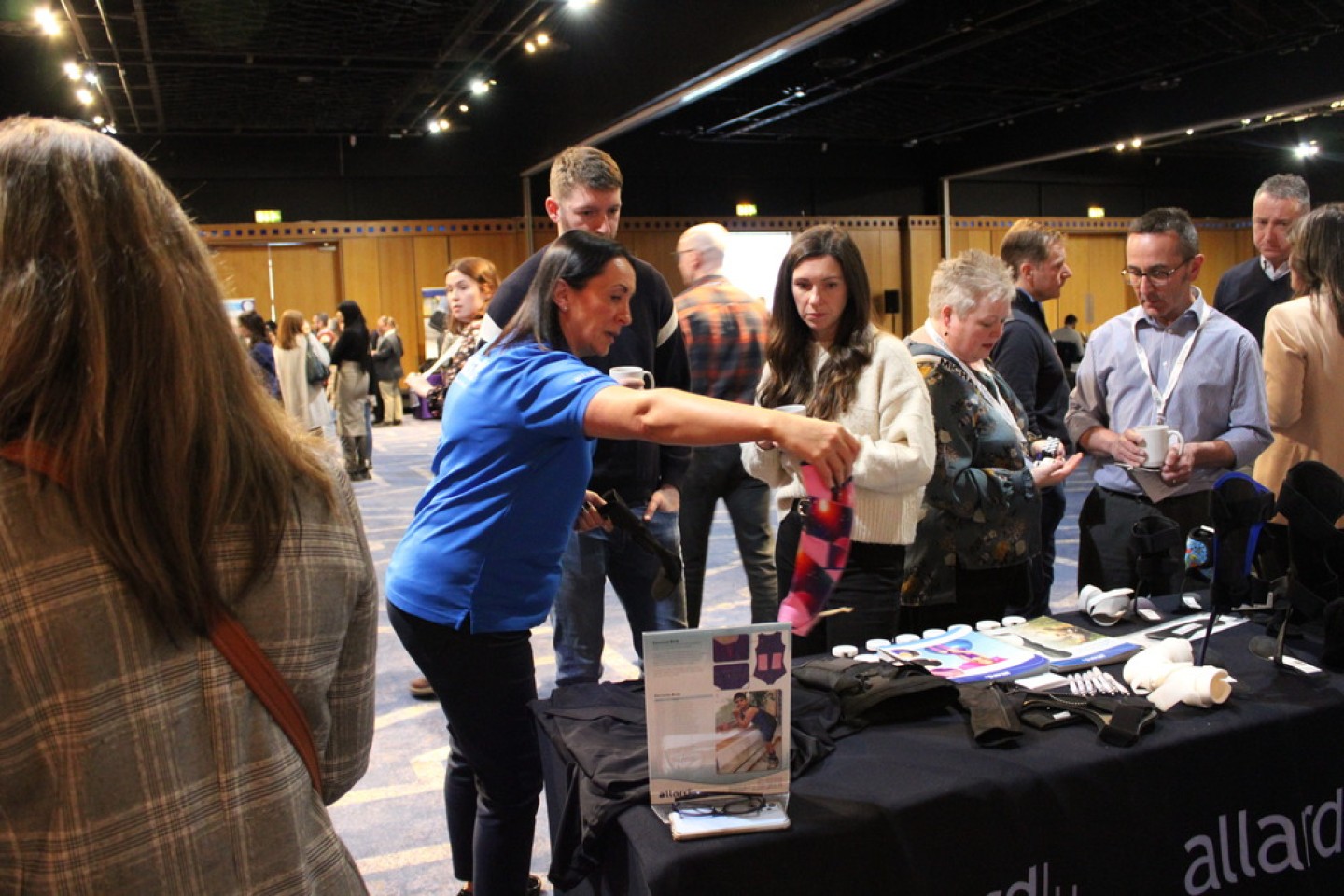 Woman showcasing her products at her exhibition stand.